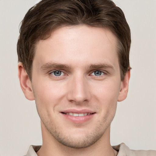 Joyful white young-adult male with short  brown hair and grey eyes