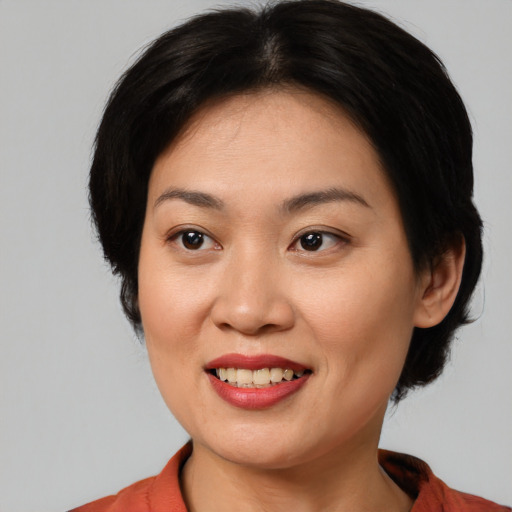 Joyful asian young-adult female with medium  brown hair and brown eyes