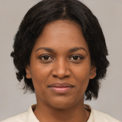 Joyful black young-adult female with medium  brown hair and brown eyes