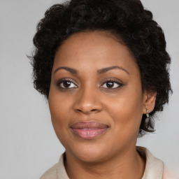 Joyful black adult female with medium  brown hair and brown eyes