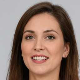 Joyful white young-adult female with long  brown hair and grey eyes