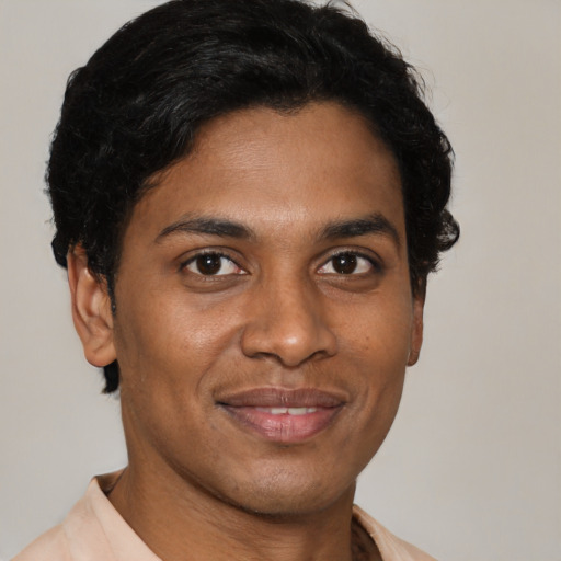 Joyful latino young-adult male with short  brown hair and brown eyes