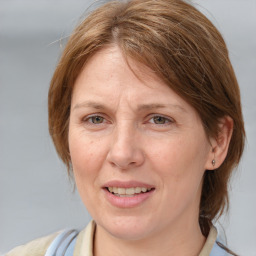 Joyful white adult female with medium  brown hair and blue eyes