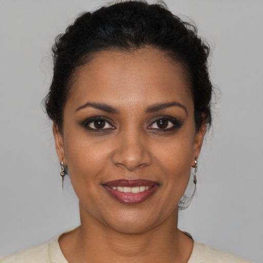 Joyful black young-adult female with short  brown hair and brown eyes