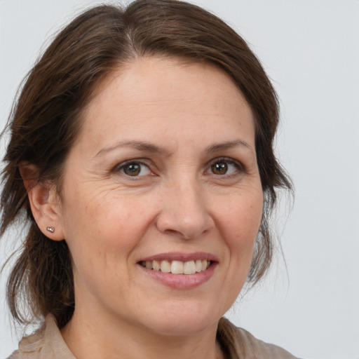 Joyful white adult female with medium  brown hair and brown eyes