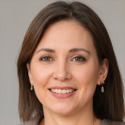 Joyful white adult female with medium  brown hair and grey eyes