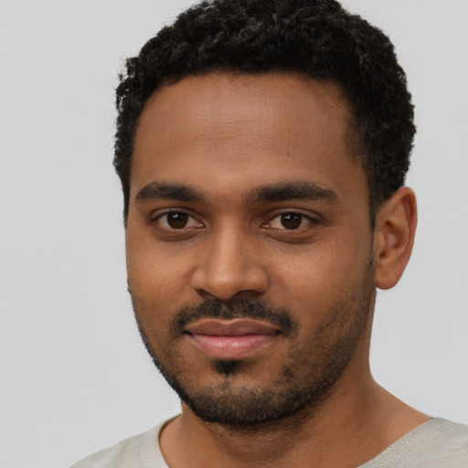Joyful black young-adult male with short  black hair and brown eyes