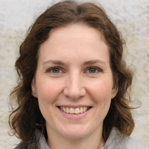 Joyful white adult female with medium  brown hair and green eyes