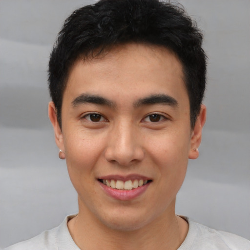 Joyful asian young-adult male with short  brown hair and brown eyes