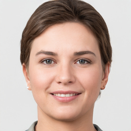 Joyful white young-adult female with short  brown hair and grey eyes