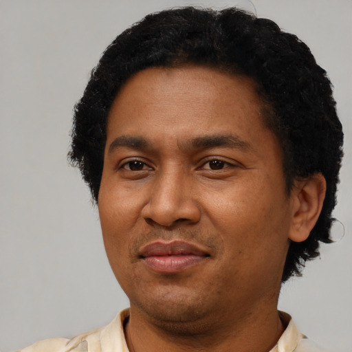 Joyful latino adult male with short  brown hair and brown eyes