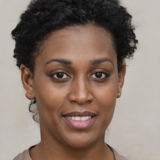Joyful black young-adult female with short  brown hair and brown eyes