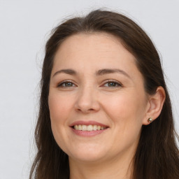 Joyful white adult female with long  brown hair and brown eyes