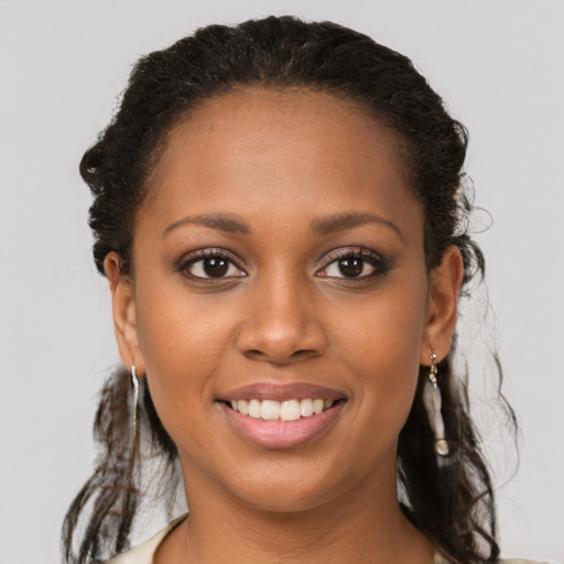 Joyful black young-adult female with long  brown hair and brown eyes