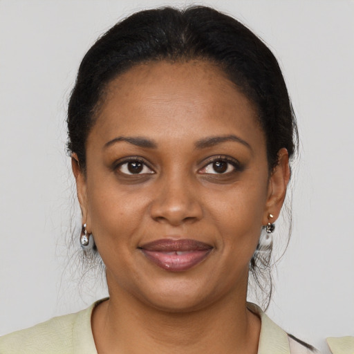 Joyful black young-adult female with long  brown hair and brown eyes