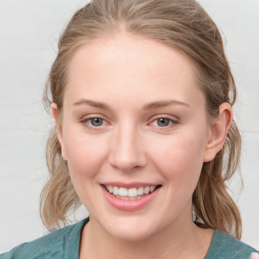 Joyful white young-adult female with medium  brown hair and blue eyes