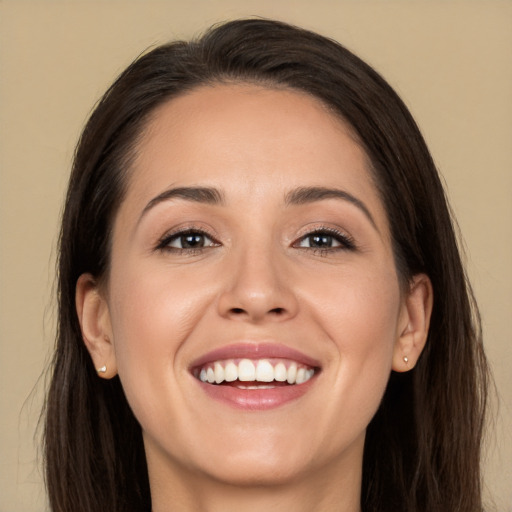 Joyful white young-adult female with long  brown hair and brown eyes