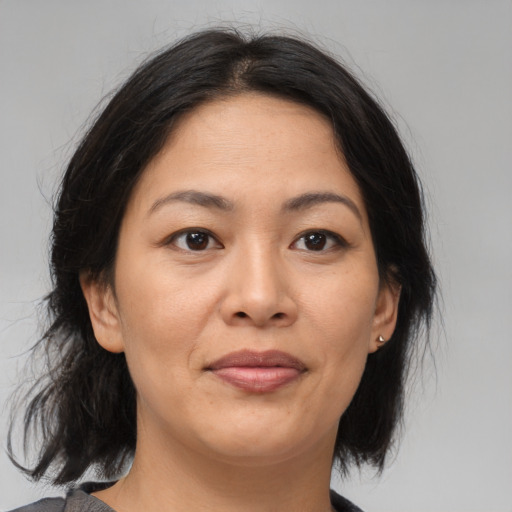 Joyful asian adult female with medium  brown hair and brown eyes