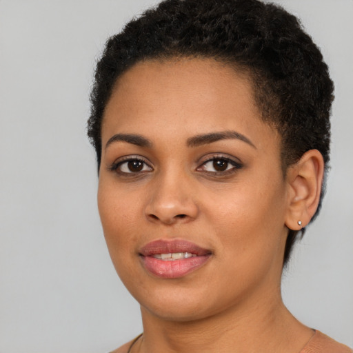 Joyful black young-adult female with short  brown hair and brown eyes