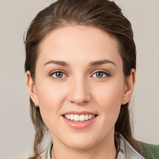 Joyful white young-adult female with medium  brown hair and grey eyes