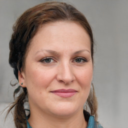 Joyful white adult female with medium  brown hair and blue eyes