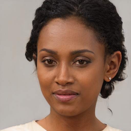 Joyful black young-adult female with medium  brown hair and brown eyes