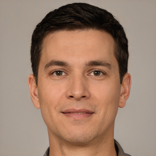 Joyful white young-adult male with short  brown hair and brown eyes