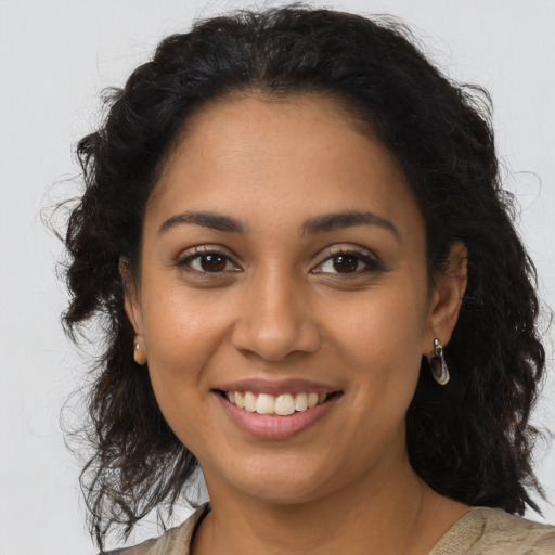 Joyful latino young-adult female with long  brown hair and brown eyes