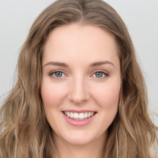 Joyful white young-adult female with long  brown hair and green eyes