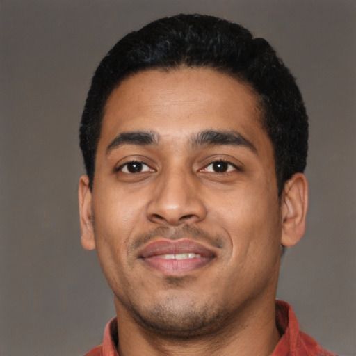 Joyful latino young-adult male with short  black hair and brown eyes