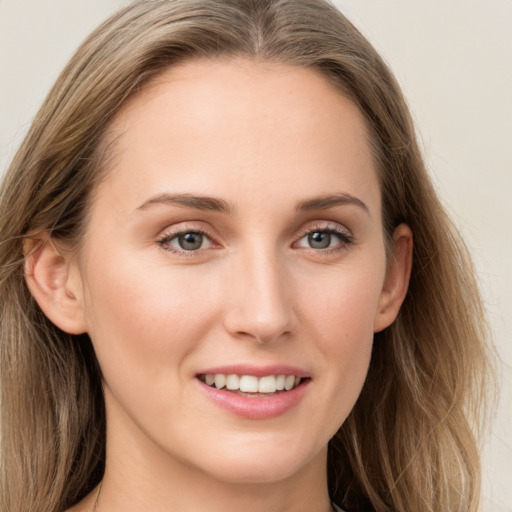 Joyful white young-adult female with long  brown hair and grey eyes