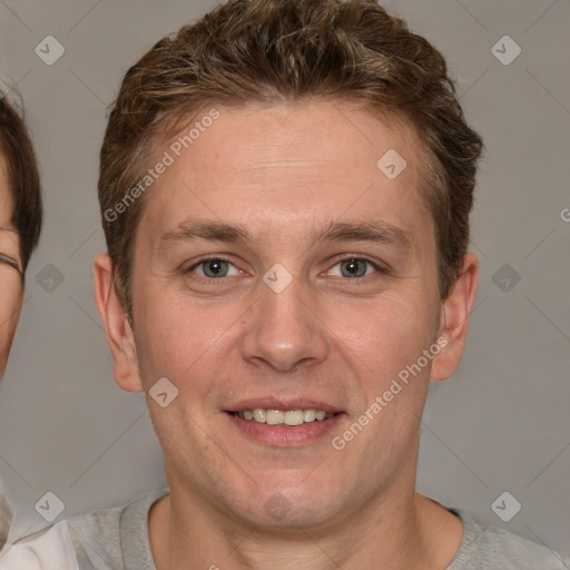 Joyful white adult male with short  brown hair and grey eyes