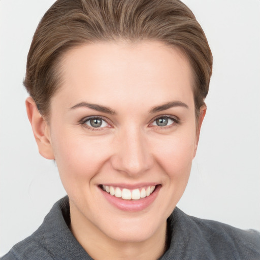 Joyful white young-adult female with short  brown hair and grey eyes