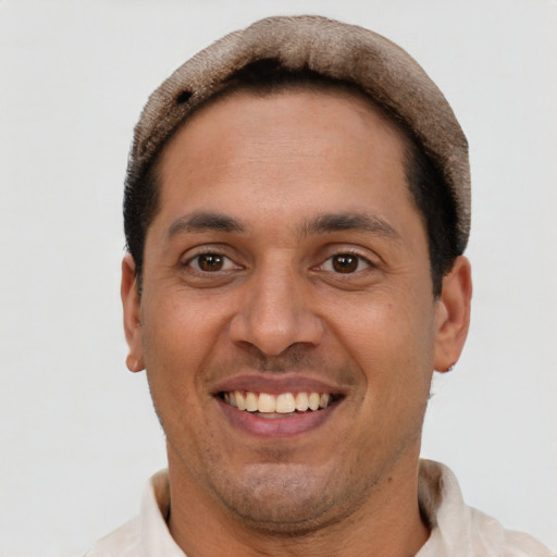 Joyful latino young-adult male with short  brown hair and brown eyes
