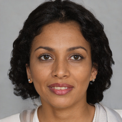 Joyful black young-adult female with medium  brown hair and brown eyes