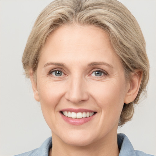 Joyful white adult female with medium  brown hair and grey eyes