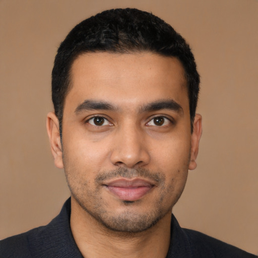 Joyful latino young-adult male with short  black hair and brown eyes