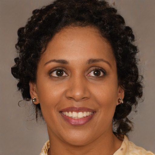 Joyful black young-adult female with medium  brown hair and brown eyes