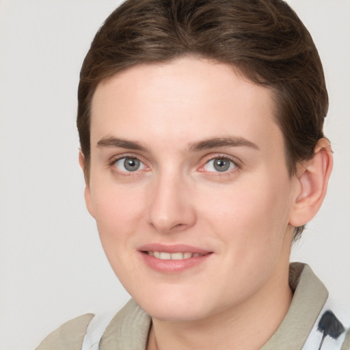 Joyful white young-adult female with short  brown hair and grey eyes