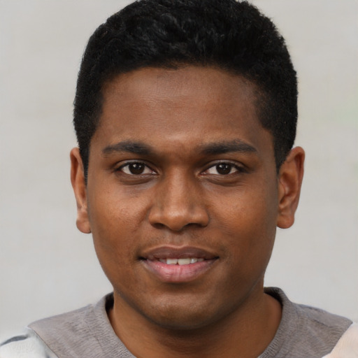 Joyful black young-adult male with short  black hair and brown eyes