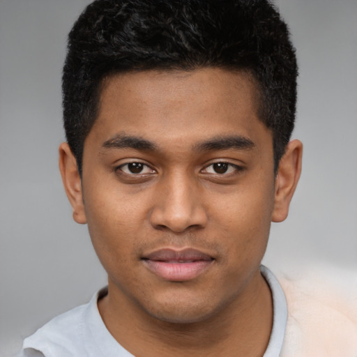 Joyful black young-adult male with short  brown hair and brown eyes