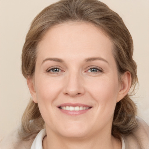 Joyful white adult female with medium  brown hair and grey eyes