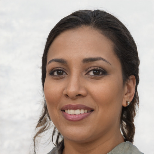 Joyful latino young-adult female with medium  brown hair and brown eyes