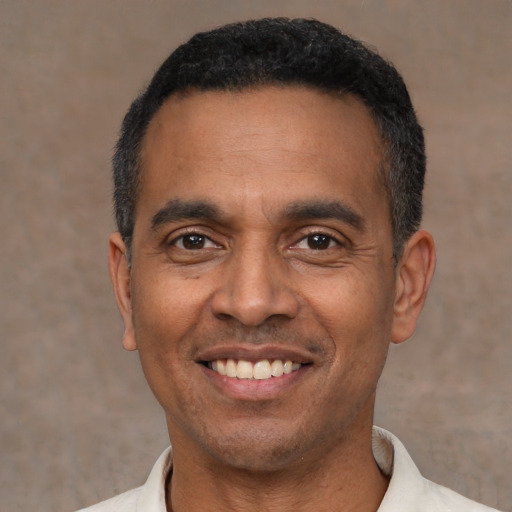 Joyful latino adult male with short  black hair and brown eyes