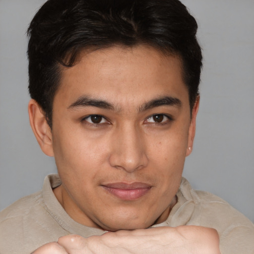 Joyful latino young-adult male with short  brown hair and brown eyes