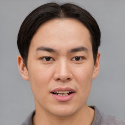 Joyful asian young-adult male with short  brown hair and brown eyes