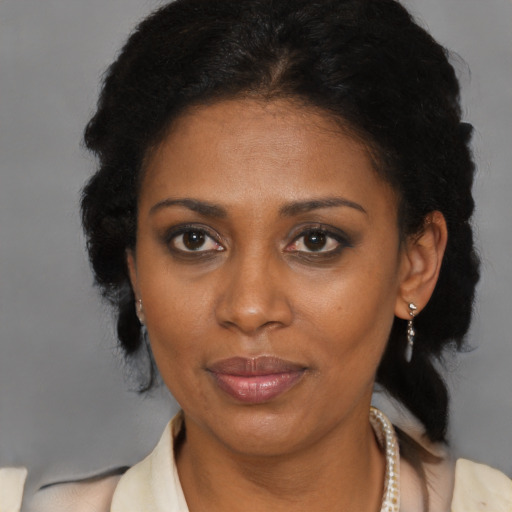 Joyful black adult female with medium  brown hair and brown eyes
