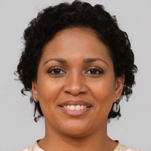 Joyful black young-adult female with short  brown hair and brown eyes