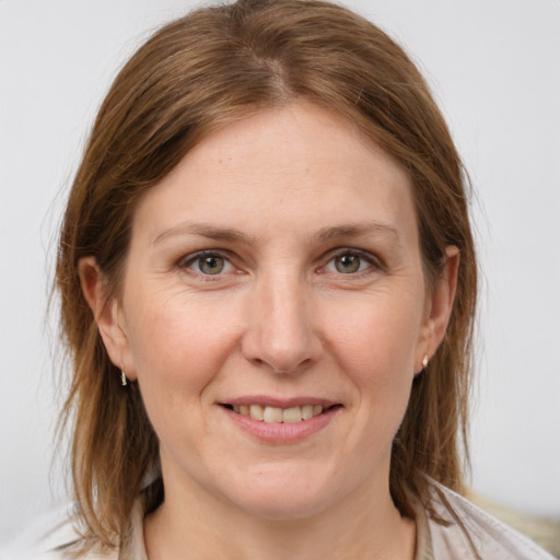 Joyful white young-adult female with medium  brown hair and grey eyes