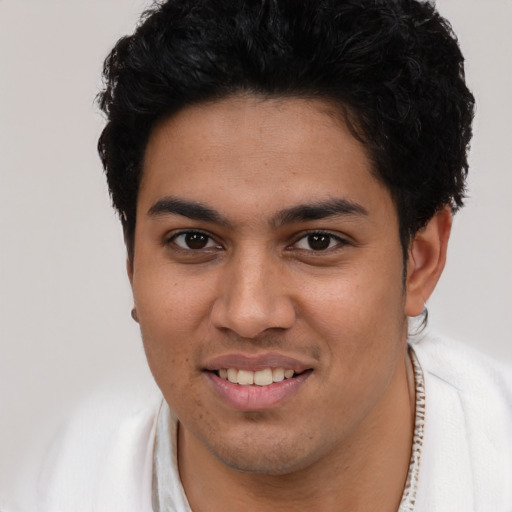 Joyful latino young-adult male with short  brown hair and brown eyes